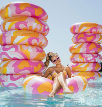 woman in pool with Barbie paisley ring pool floats