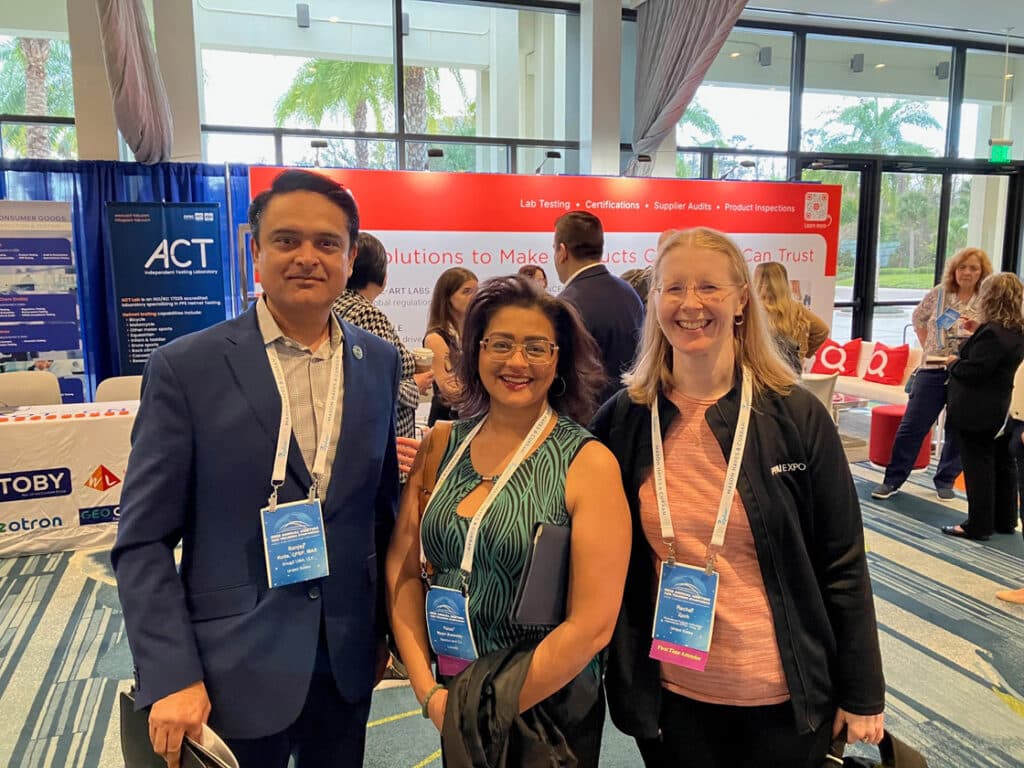 three smiling people at a conference